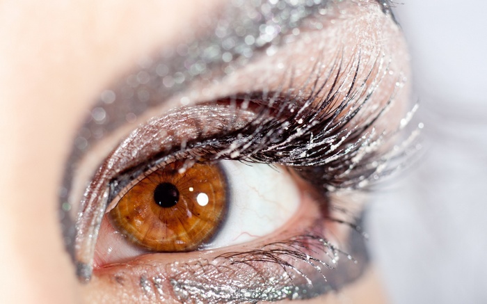 Close-up of a human eye with glitter makeup