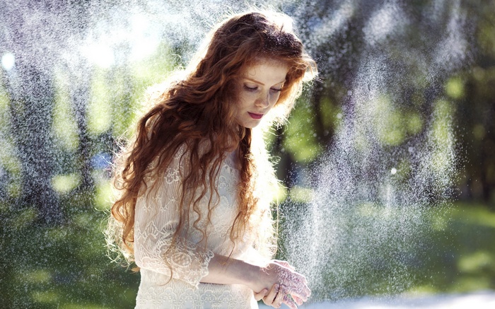 Woman with long red hair in a white dress