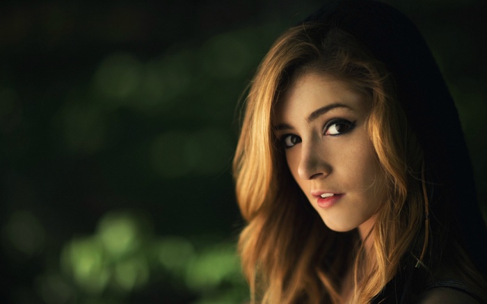 Woman with blonde hair and dark hood