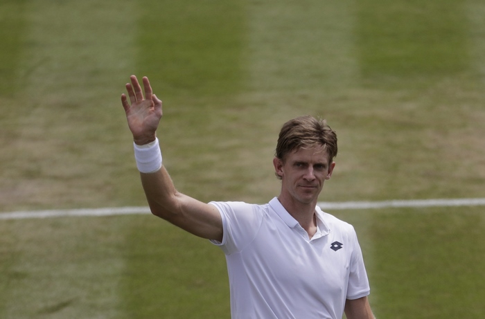 Kevin Anderson waves on a tennis court