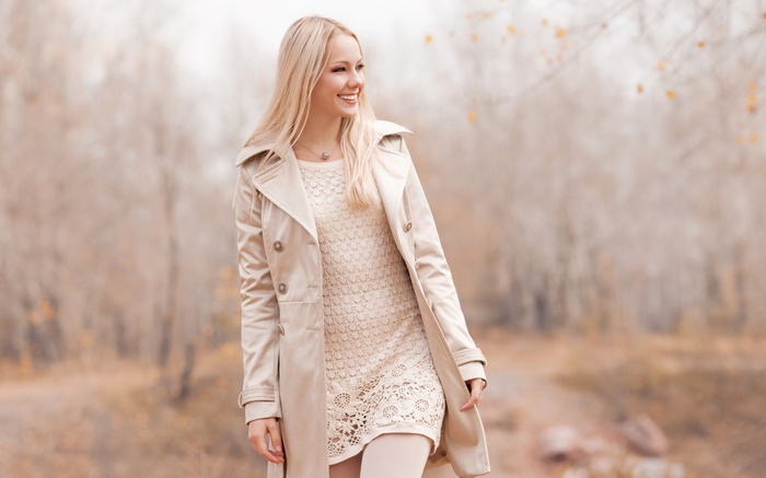Woman in trench coat and dress outdoors