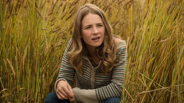 Britt Robertson in a wheat field