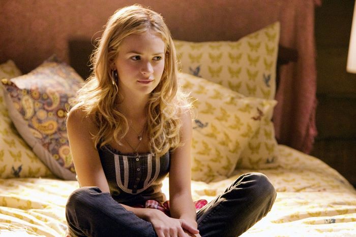 Britt Robertson sitting on a bed