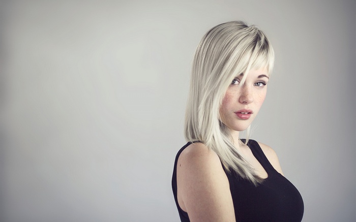 Woman with blonde hair wearing a black tank top