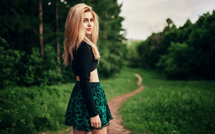 Woman in a black top and leopard skirt in a forest