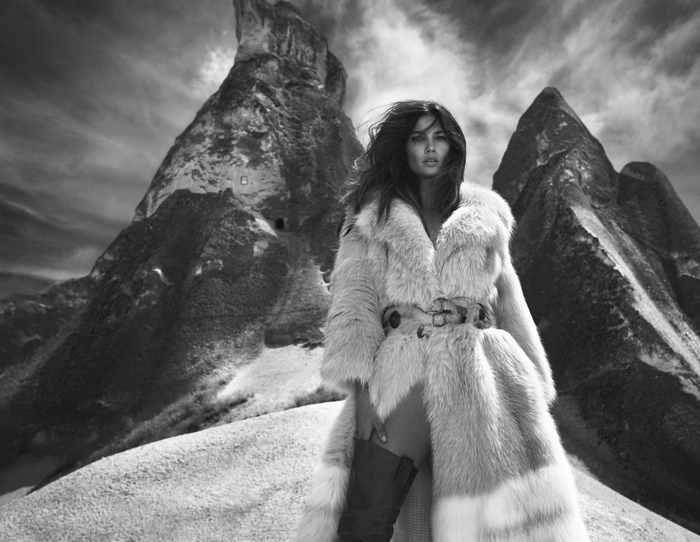 Lily Aldridge in a fur coat in a rocky landscape