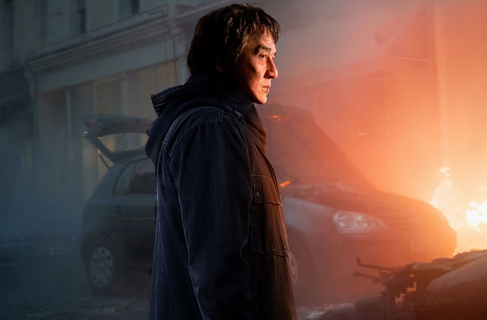 Jackie Chan in a scene with a burning car