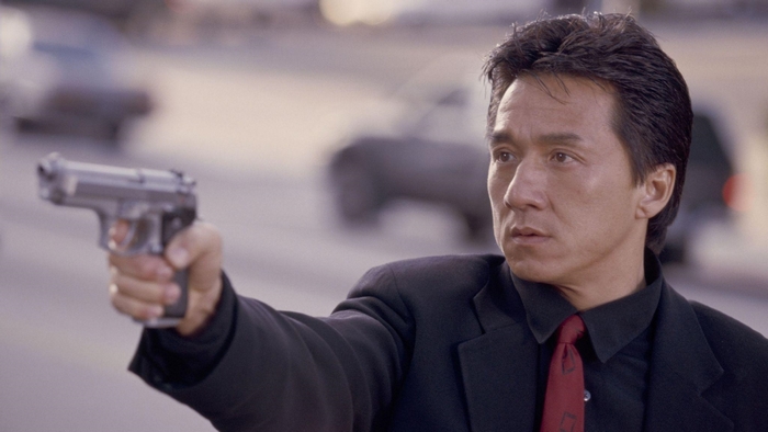Jackie Chan holding a gun