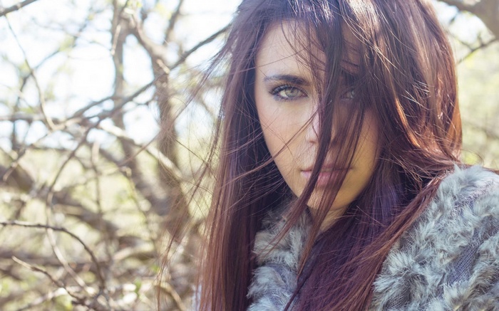 Woman with hair covering face in nature