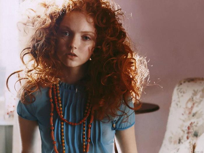 Lily Cole with red curly hair and blue shirt