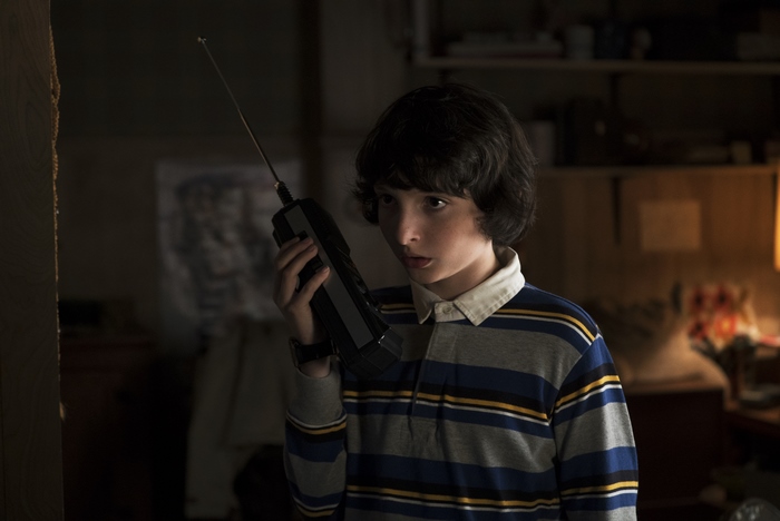 Finn Wolfhard holding a walkie-talkie