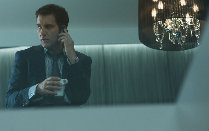 Clive Owen on the phone with a cup