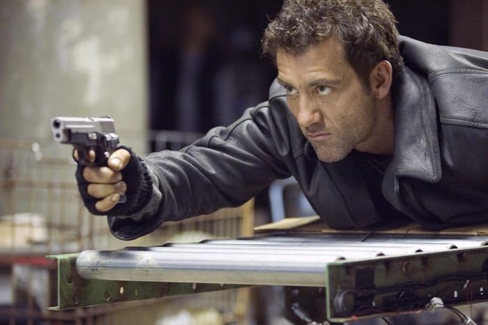 Clive Owen aiming a handgun