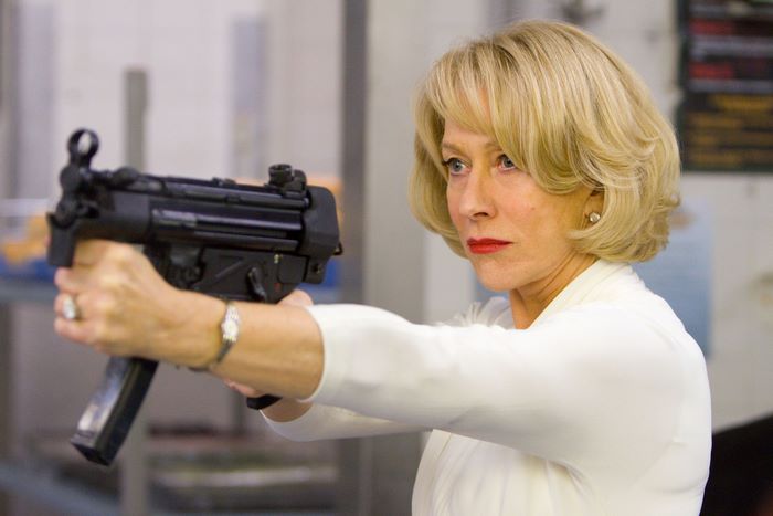 Helen Mirren holding a submachine gun