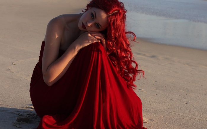 Woman in red dress on a beach