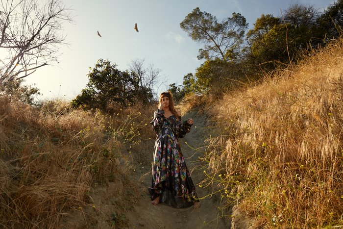 Sofia Boutella in a floral dress in a dry landscape