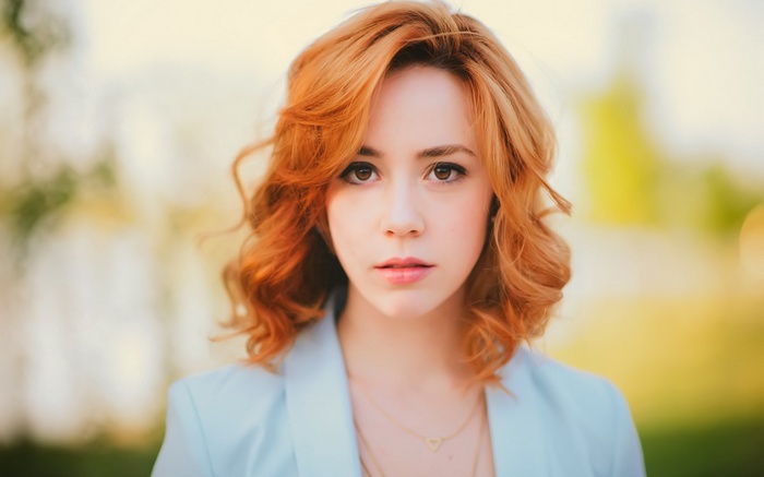 Woman with red hair wearing a blue jacket