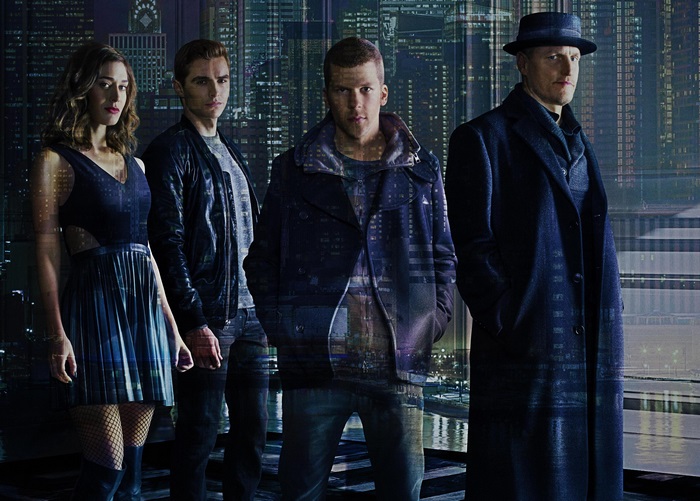 Four people standing in front of a city skyline