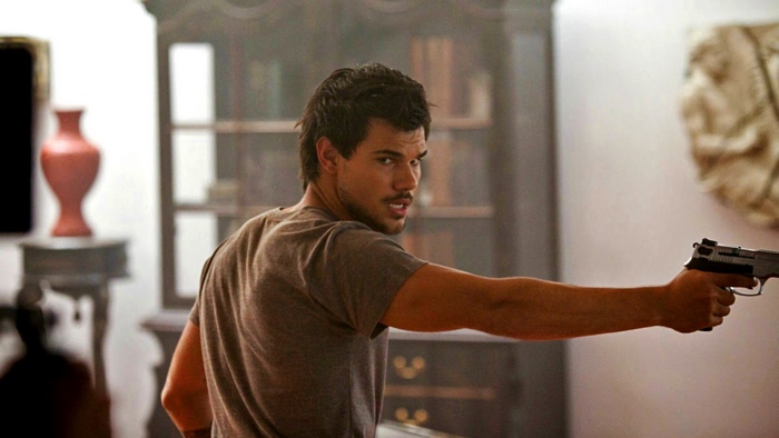 Taylor Lautner holding a gun