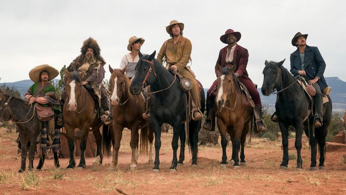 Group of men on horseback in a desert landscape