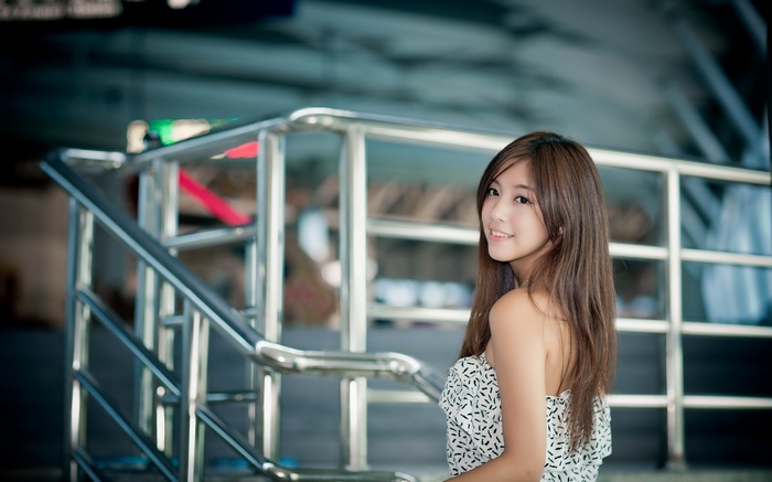 Young woman posing near a metal railing