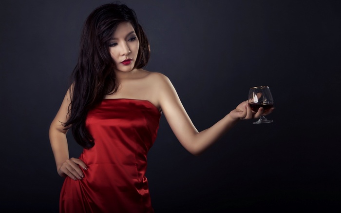 Woman in red dress holding a glass of wine