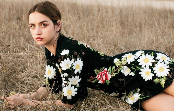 Ana de Armas in floral black dress lying in grass