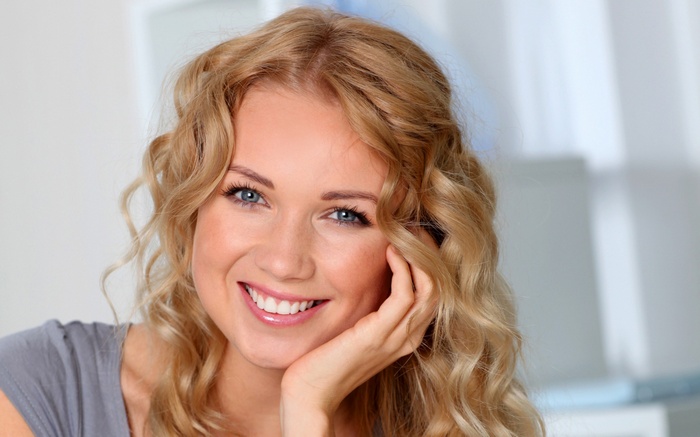 Woman with blonde curly hair smiling