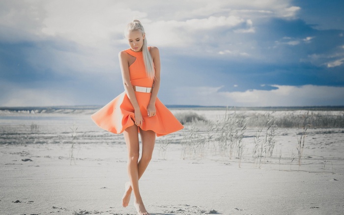 Woman in orange dress on a sandy beach
