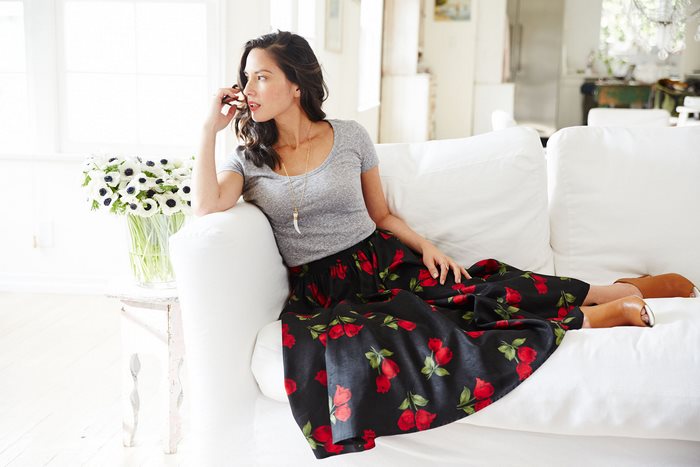 Olivia Munn sitting on a couch