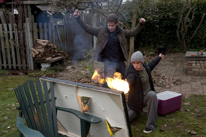 Two men with fire in a backyard