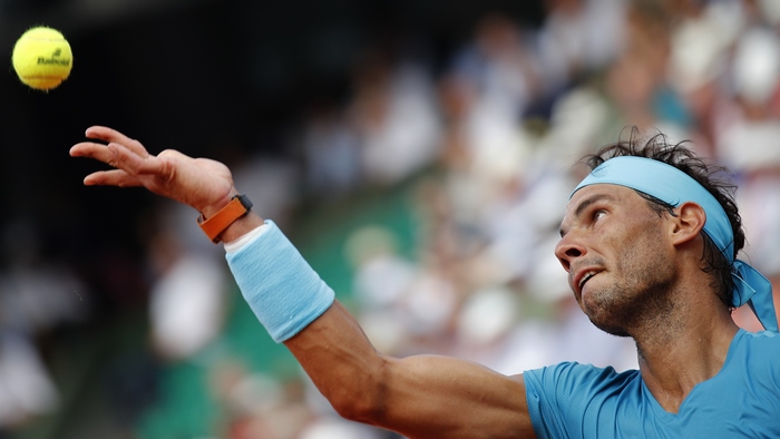 Rafael Nadal serving a tennis ball