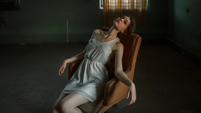 Woman in polka dot dress sitting in a chair