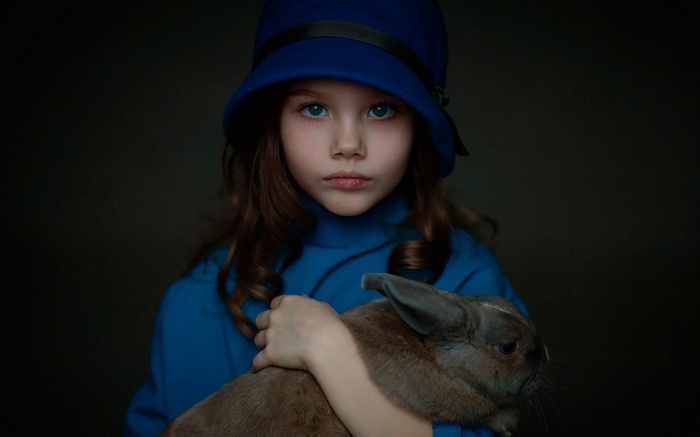 Girl in blue hat holding a rabbit