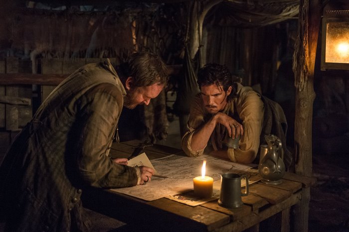 Two men looking at a map in a dimly lit room
