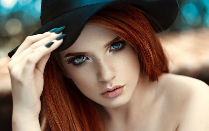 Woman in black hat with red hair