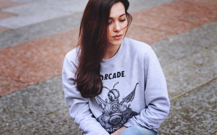 Woman wearing a grey sweatshirt with a graphic print