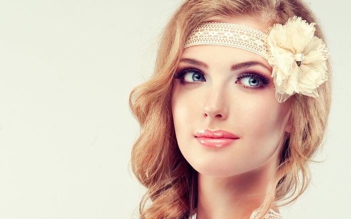 Woman with blonde wavy hair and flower headband