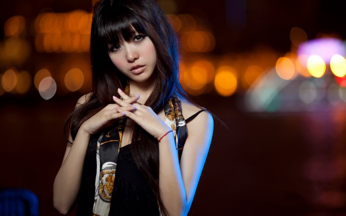 Woman with scarf in front of bokeh lights