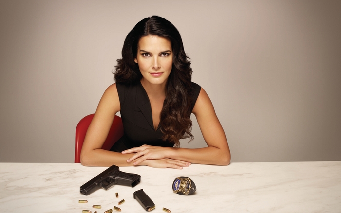 Angie Harmon with gun and badge