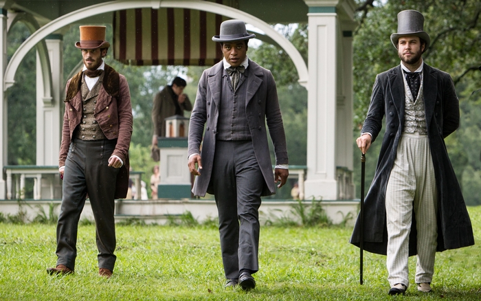 Three men in period attire standing outdoors