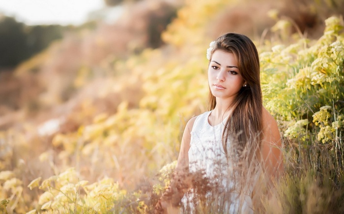 Young woman with flower in hair in a field