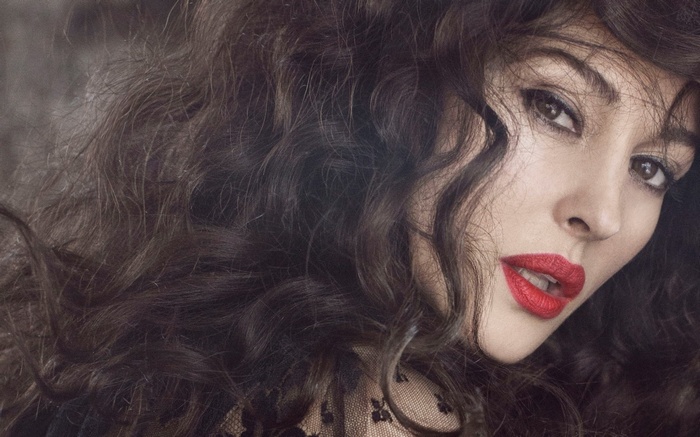 Monica Bellucci with dark curly hair and red lipstick