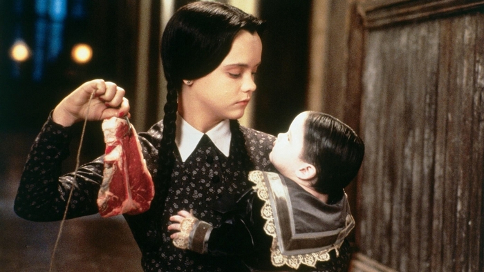 Wednesday Addams holding raw meat and baby Pubert