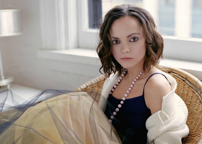 Christina Ricci in a wicker chair