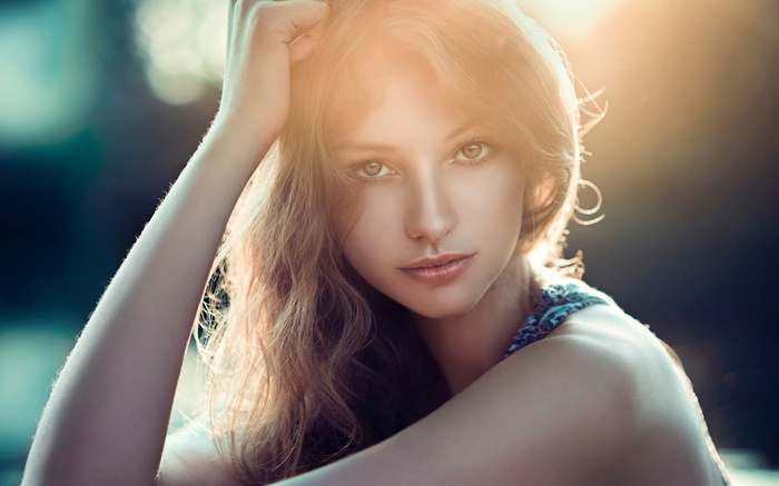 Woman with hand on head in sunlight