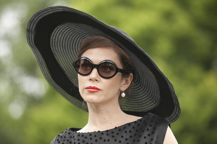 Anna Friel wearing a large black hat and sunglasses