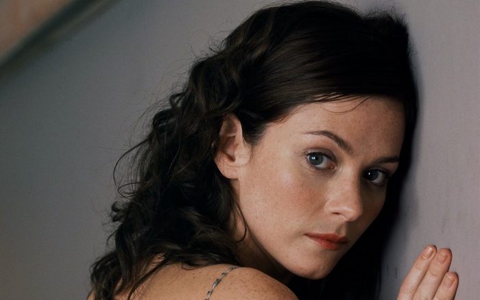 Anna Friel leaning against a wall