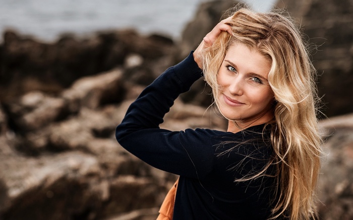 Woman with blonde hair touching her head