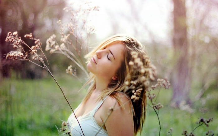Woman with eyes closed in a field